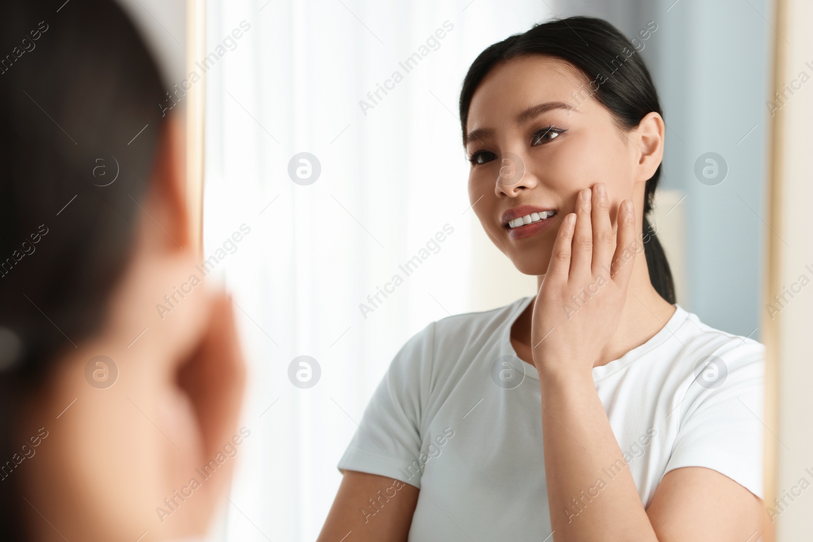 Photo of Portrait of beautiful woman near mirror indoors
