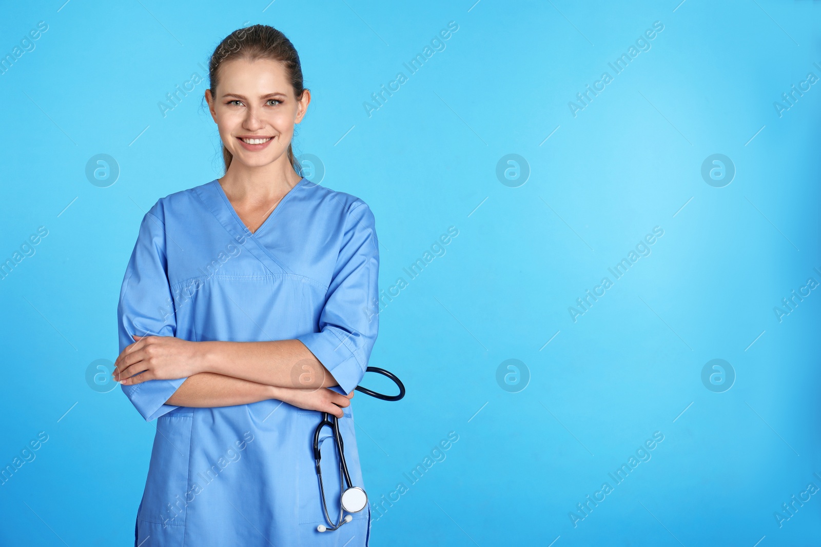 Photo of Portrait of young medical assistant with stethoscope on color background. Space for text