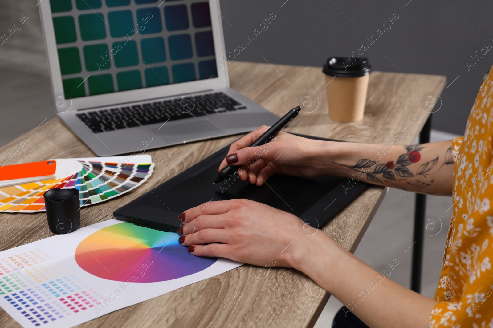 Photo of Professional designer with graphic tablet at wooden table, closeup