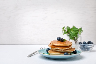 Photo of Tasty pancakes with honey and berries on table