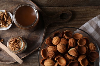 Photo of Making walnut shaped cookies. Cooked dough, caramelized condensed milk and nuts on wooden table, flat lay