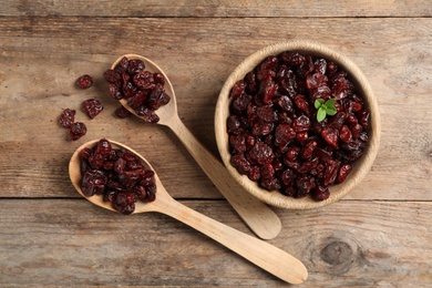 Photo of Flat lay composition with tasty dried cranberries on wooden table