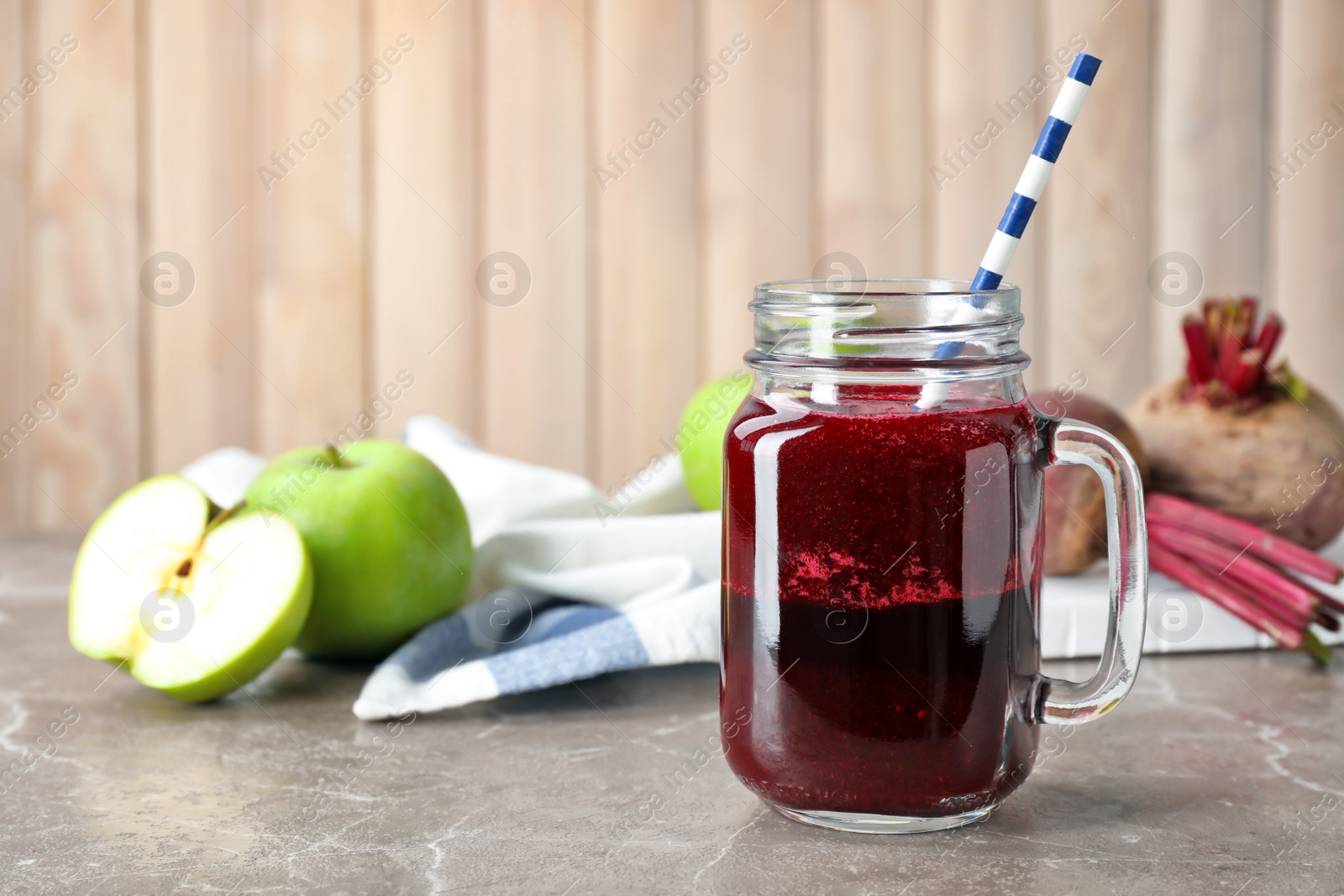 Photo of Mason jar with fresh beet juice on table