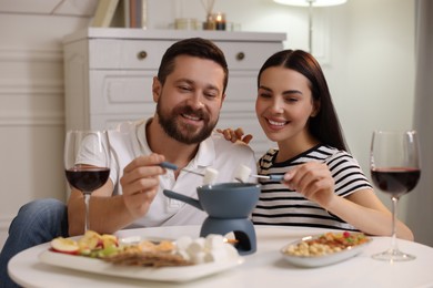 Photo of Affectionate couple enjoying fondue during romantic date at home