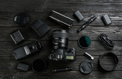 Photo of Flat lay composition with equipment for professional photographer on black wooden table