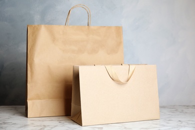 Paper shopping bags on table against color background. Mock up for design