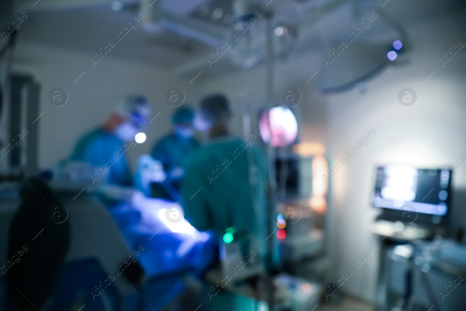 Photo of Blurred view of doctors operating patient in surgery room