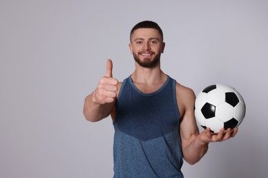Photo of Athletic young man with soccer ball on light grey background