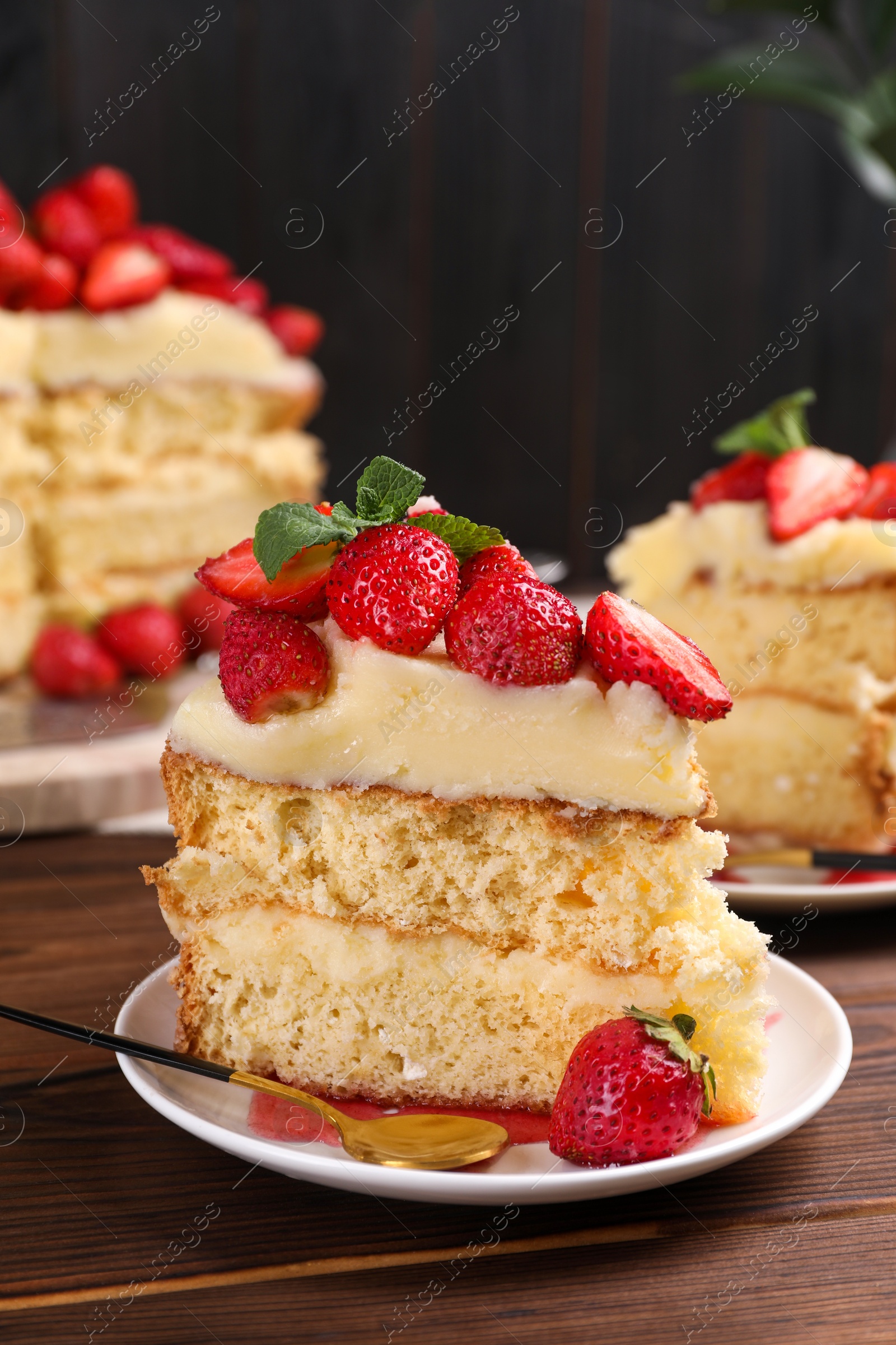 Photo of Tasty cake with fresh strawberries and mint on wooden table, closeup