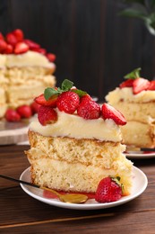 Photo of Tasty cake with fresh strawberries and mint on wooden table, closeup