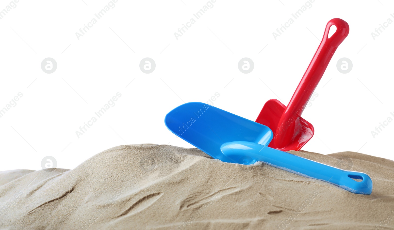 Photo of Light blue and red plastic toy shovels on pile of sand