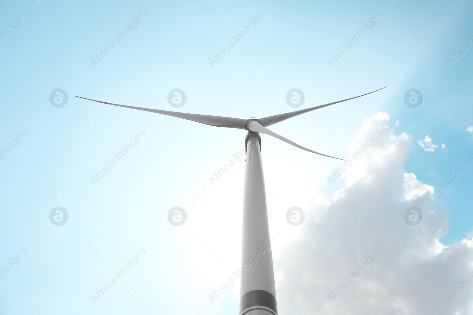 Photo of Modern wind turbine against blue sky, low angle view. Energy efficiency