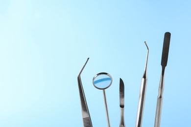Photo of Set of different dentist tools on color background, closeup. Space for text