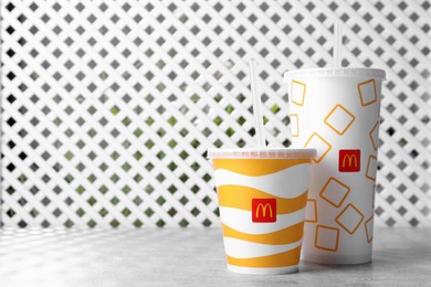 Photo of MYKOLAIV, UKRAINE - AUGUST 12, 2021: Cold McDonald's drinks on grey table. Space for text