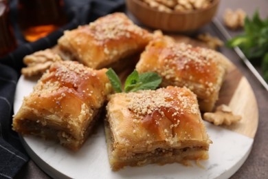 Photo of Eastern sweets. Pieces of tasty baklava on brown table, closeup