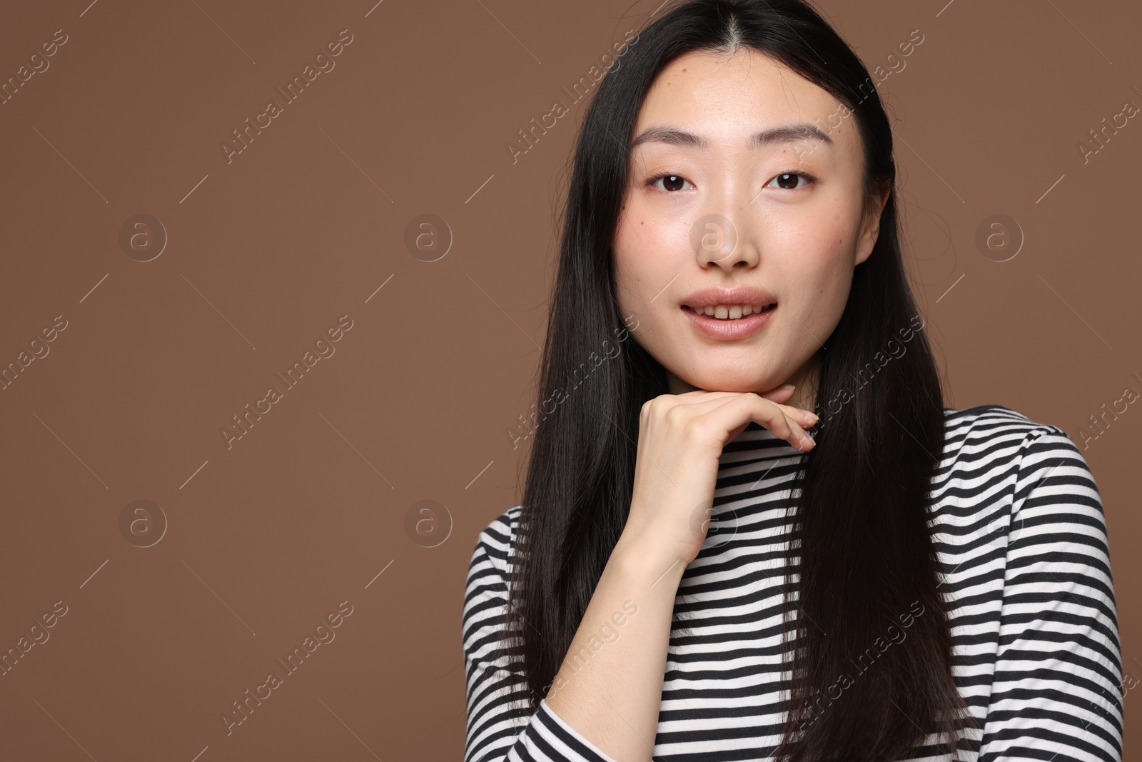 Photo of Portrait of smiling woman on brown background. Space for text