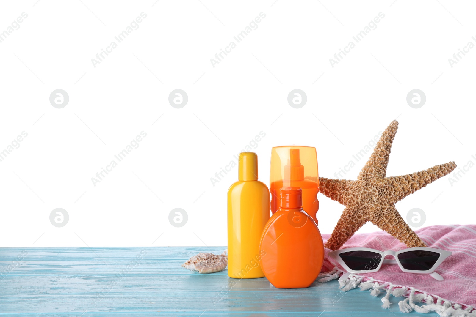 Photo of Sun protection products and beach accessories on blue wooden table against white background. Space for text