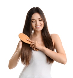 Photo of Beautiful smiling young woman with hair brush on white background