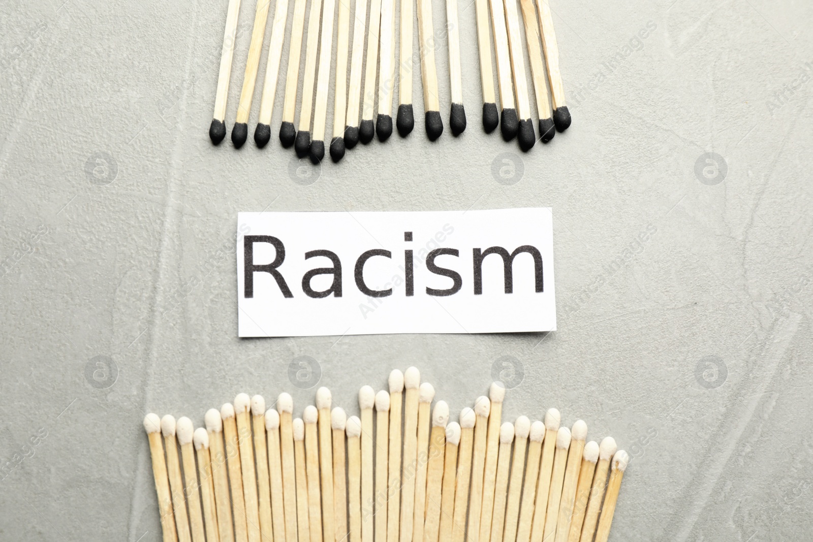 Photo of Word Racism and different matches on light grey table, flat lay