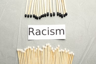 Photo of Word Racism and different matches on light grey table, flat lay