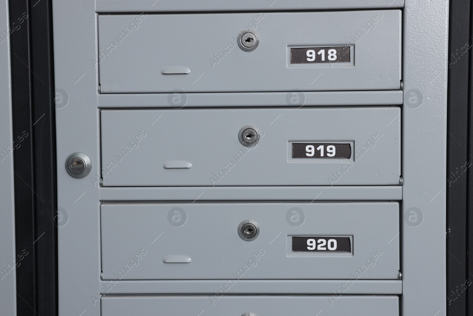 Photo of Closed metal mailboxes with keyholes and sequence numbers indoors