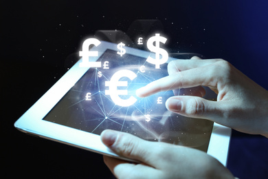 Image of Fintech concept. Woman using tablet on dark background, closeup