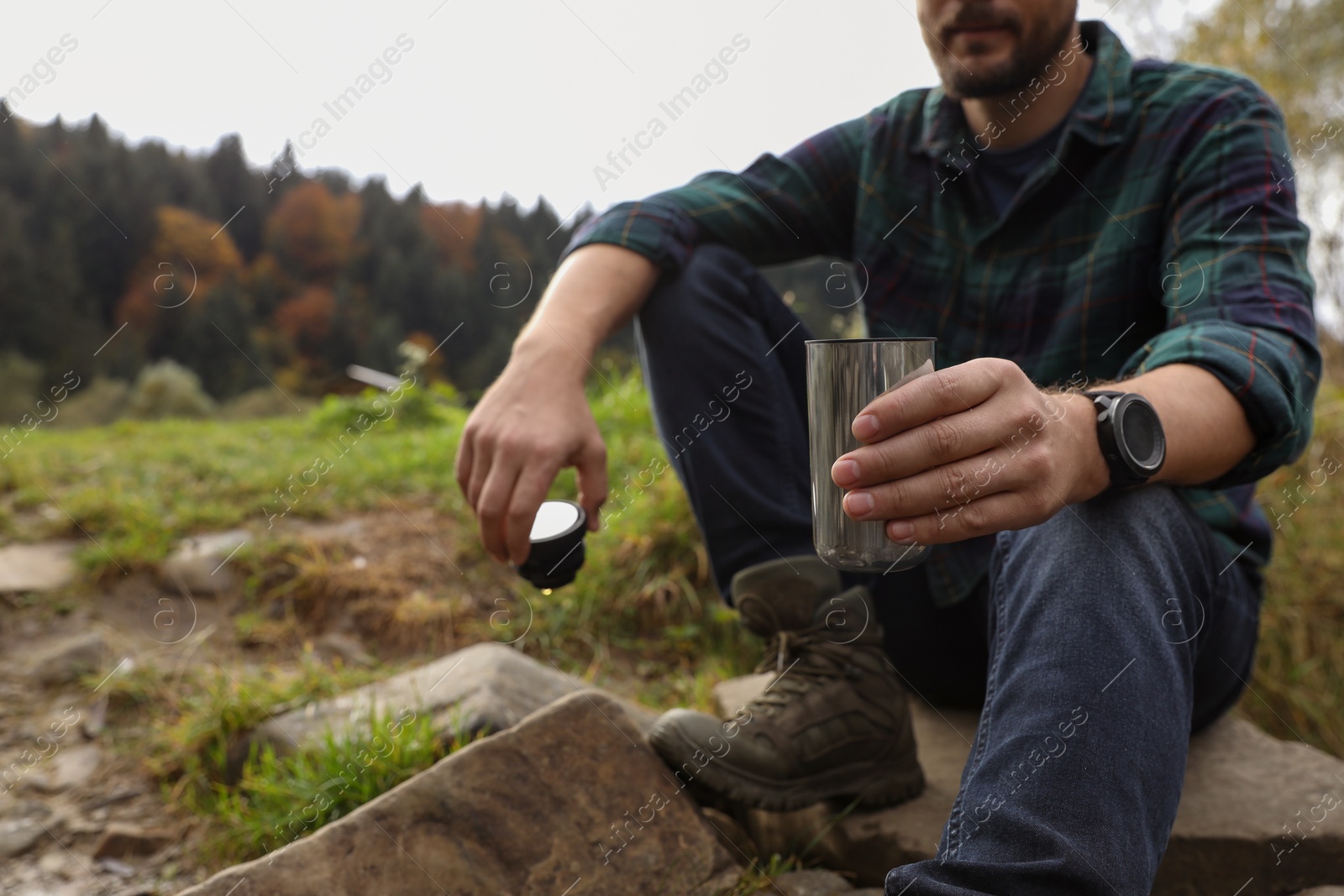 Photo of Man with thermo tumbler in nature, closeup. Space for text