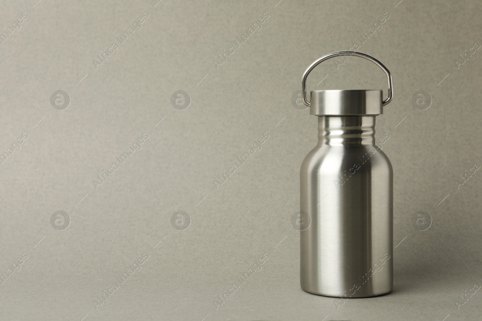 Photo of Metal bottle on grey background, space for text. Conscious consumption