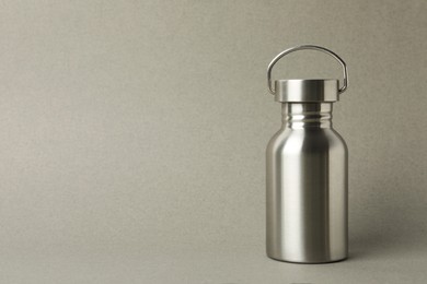 Metal bottle on grey background, space for text. Conscious consumption