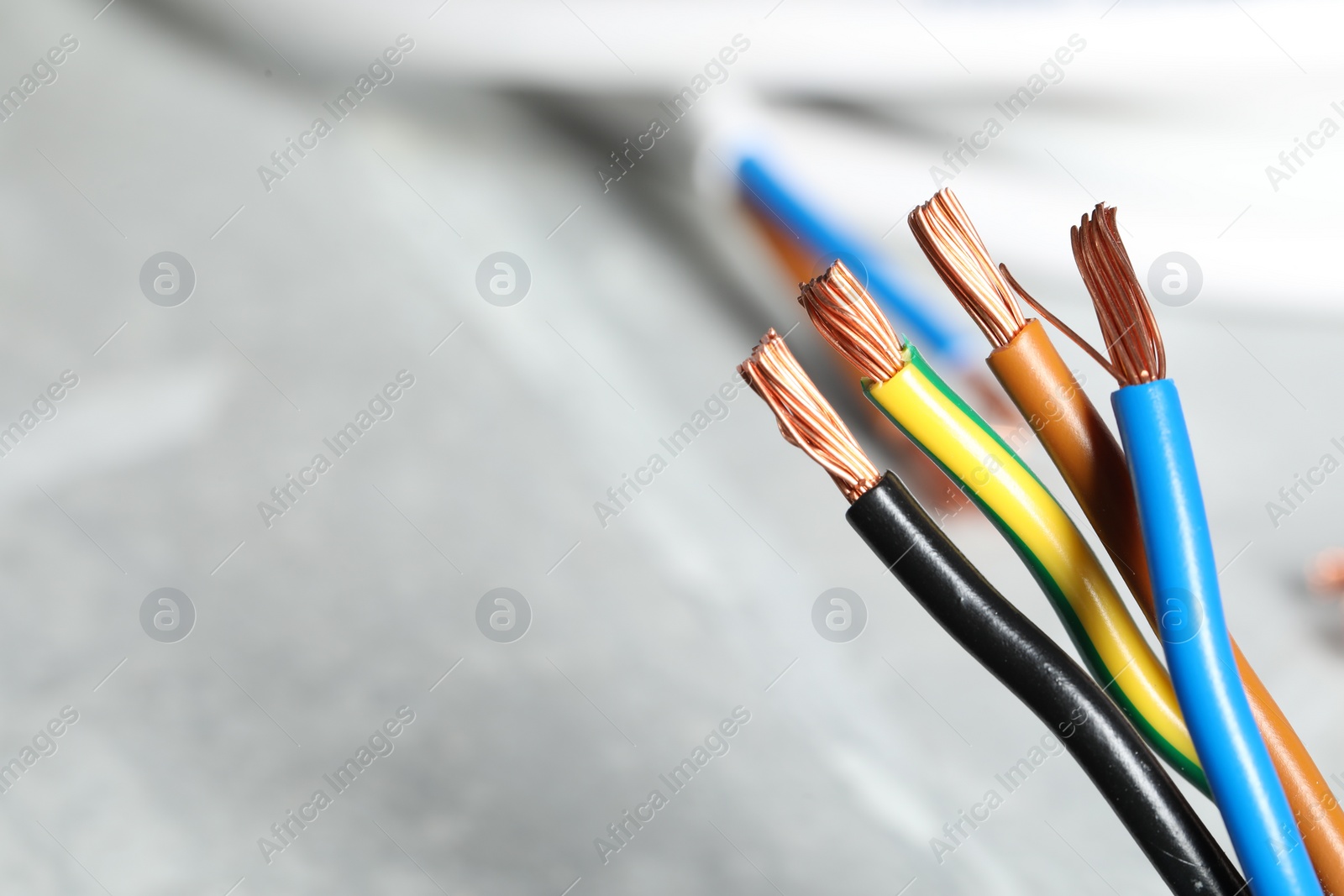 Photo of Colorful electrical wires on blurred background, closeup. Space for text