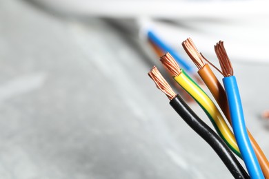 Colorful electrical wires on blurred background, closeup. Space for text