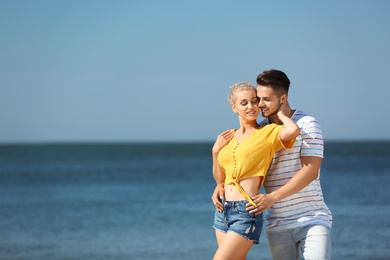 Happy young couple at beach on sunny day