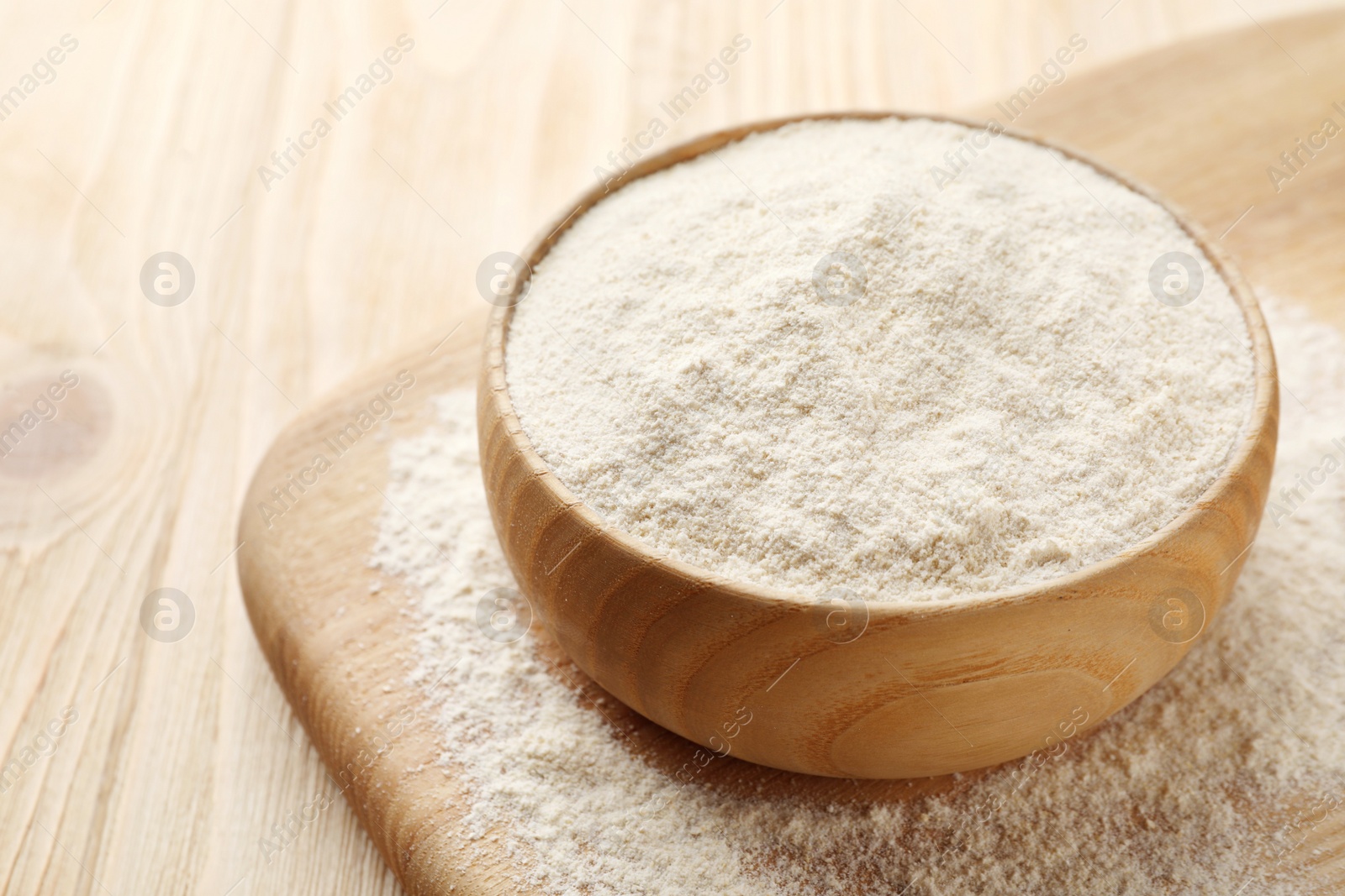 Photo of Quinoa flour in bowl on wooden table, closeup