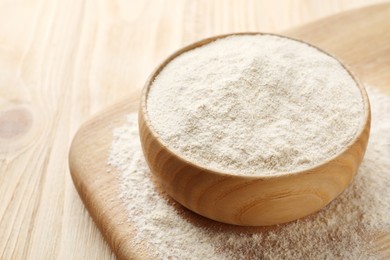 Photo of Quinoa flour in bowl on wooden table, closeup