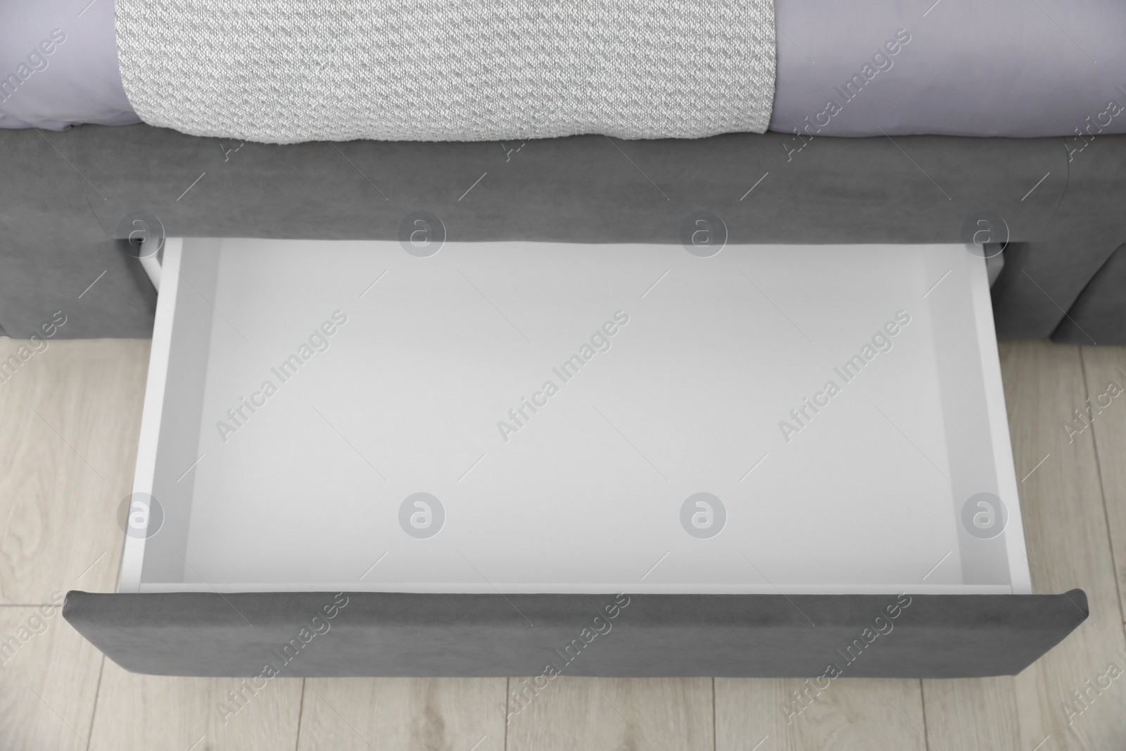 Photo of Storage drawer for bedding under modern bed in room, above view