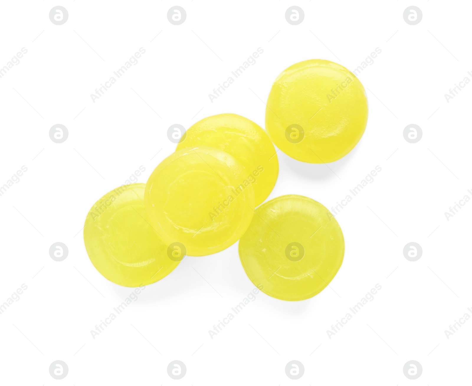 Photo of Many yellow cough drops on white background, top view