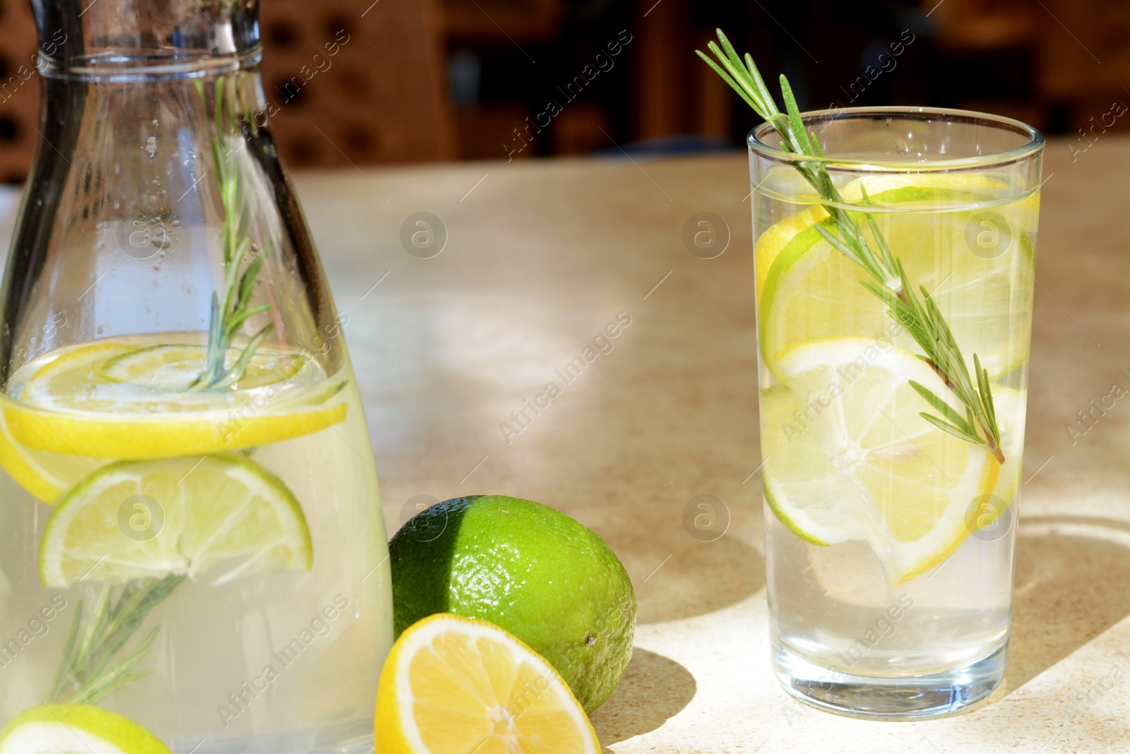 Photo of Tasty refreshing lemonade and ingredients on light table. Summer drink