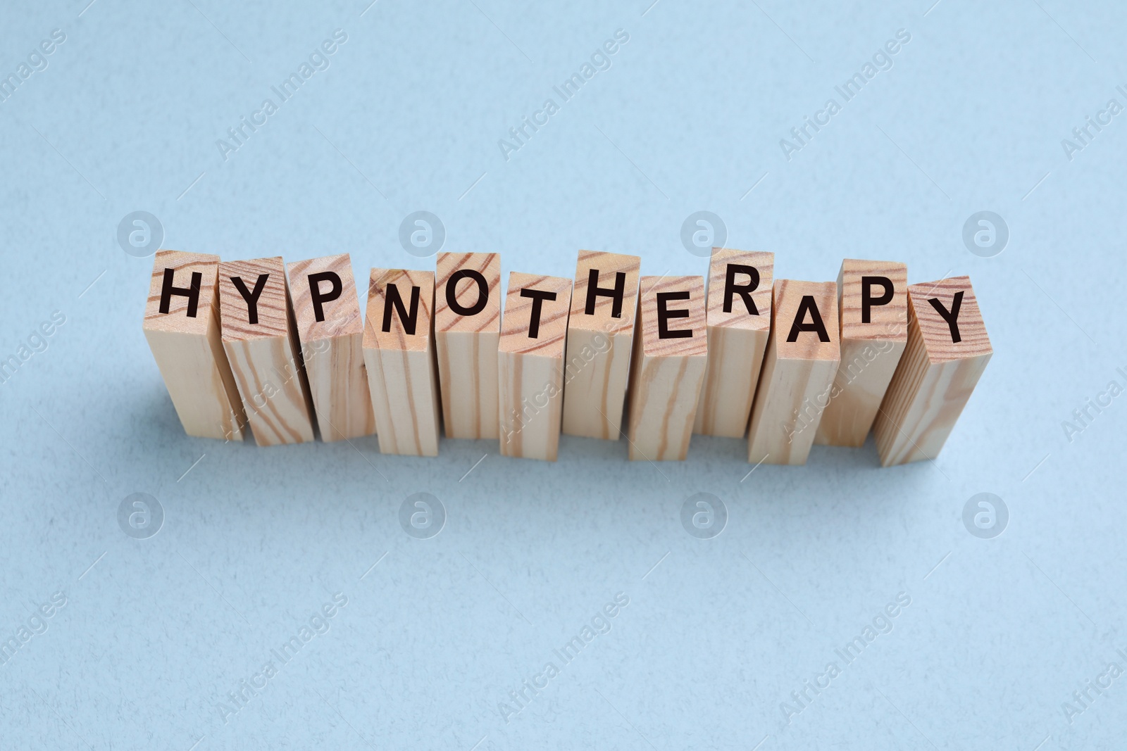 Photo of Wooden blocks with word HYPNOTHERAPY on white background, above view