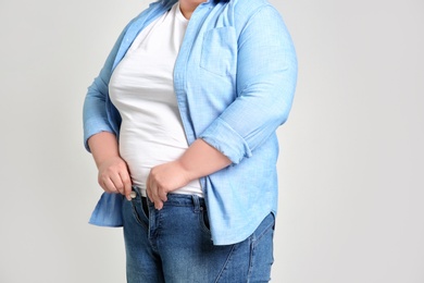 Overweight woman on light background