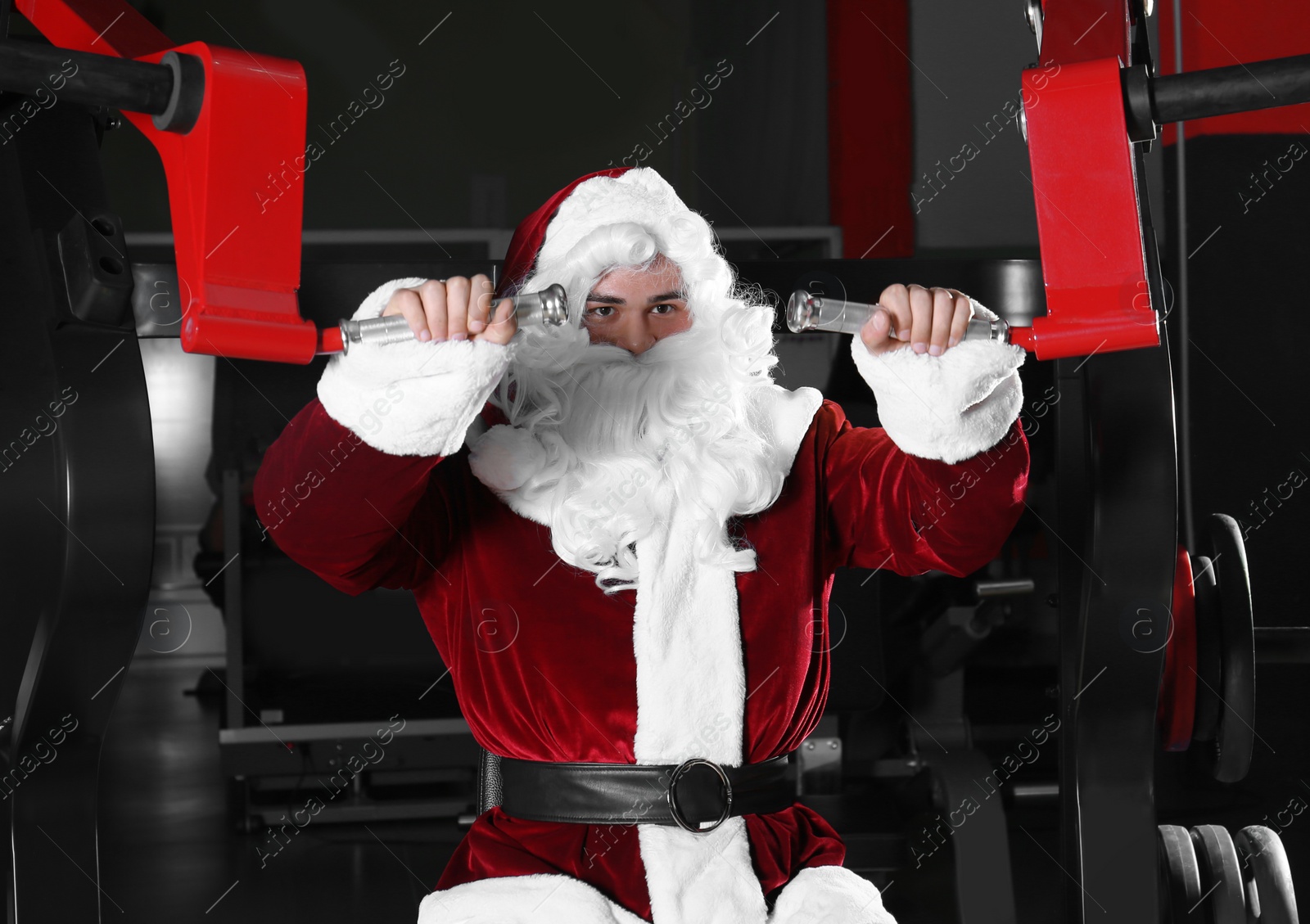 Photo of Young Santa Claus training in modern gym