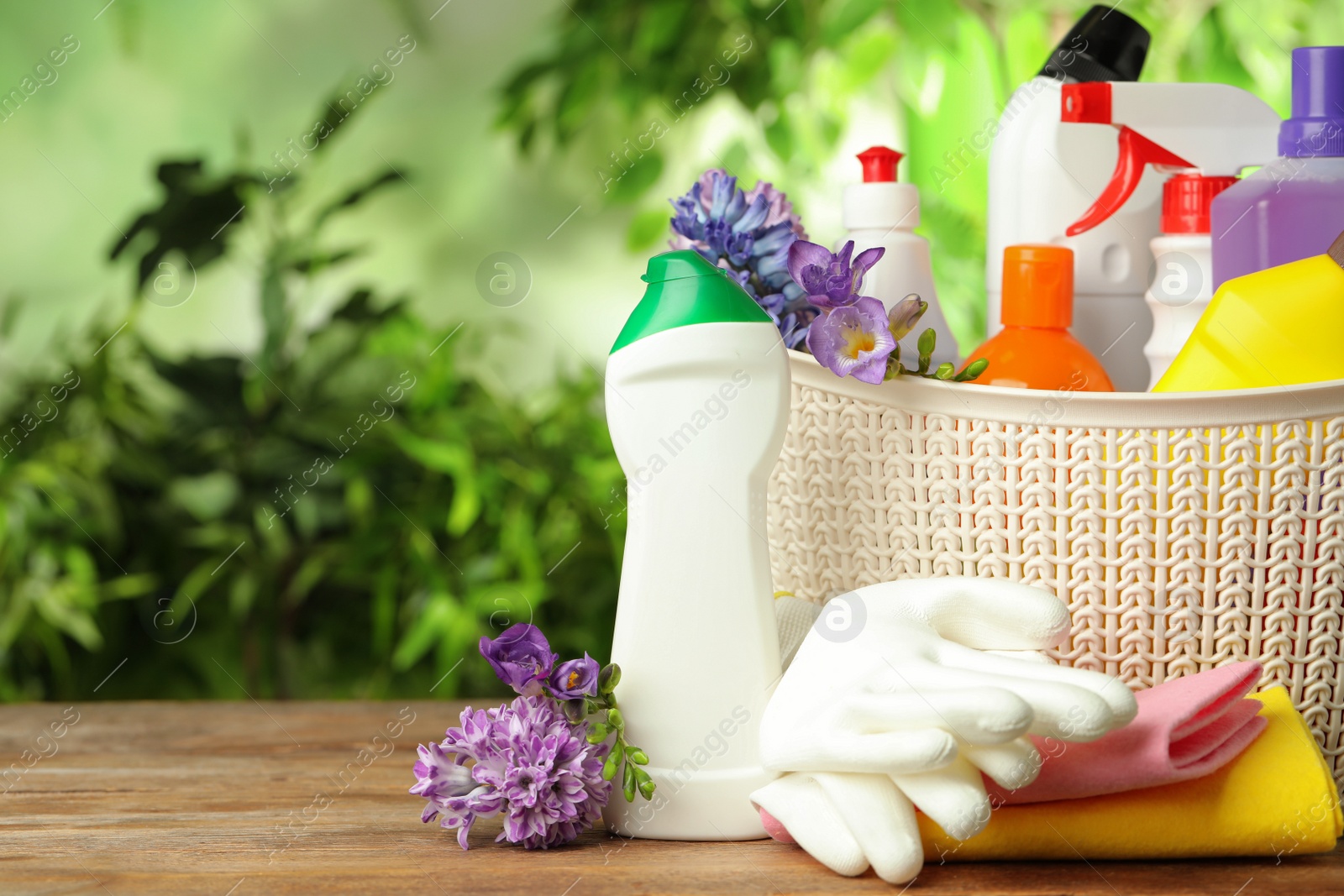 Photo of Spring flowers and cleaning supplies on wooden table