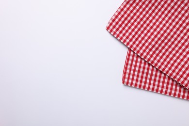 Red checkered tablecloth on white background, top view