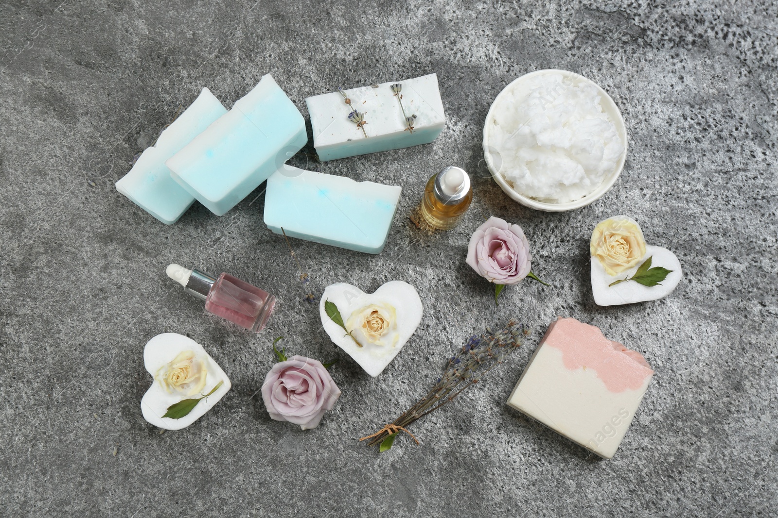 Photo of Flat lay composition with natural handmade soap and ingredients on grey stone table