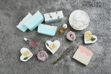 Flat lay composition with natural handmade soap and ingredients on grey stone table