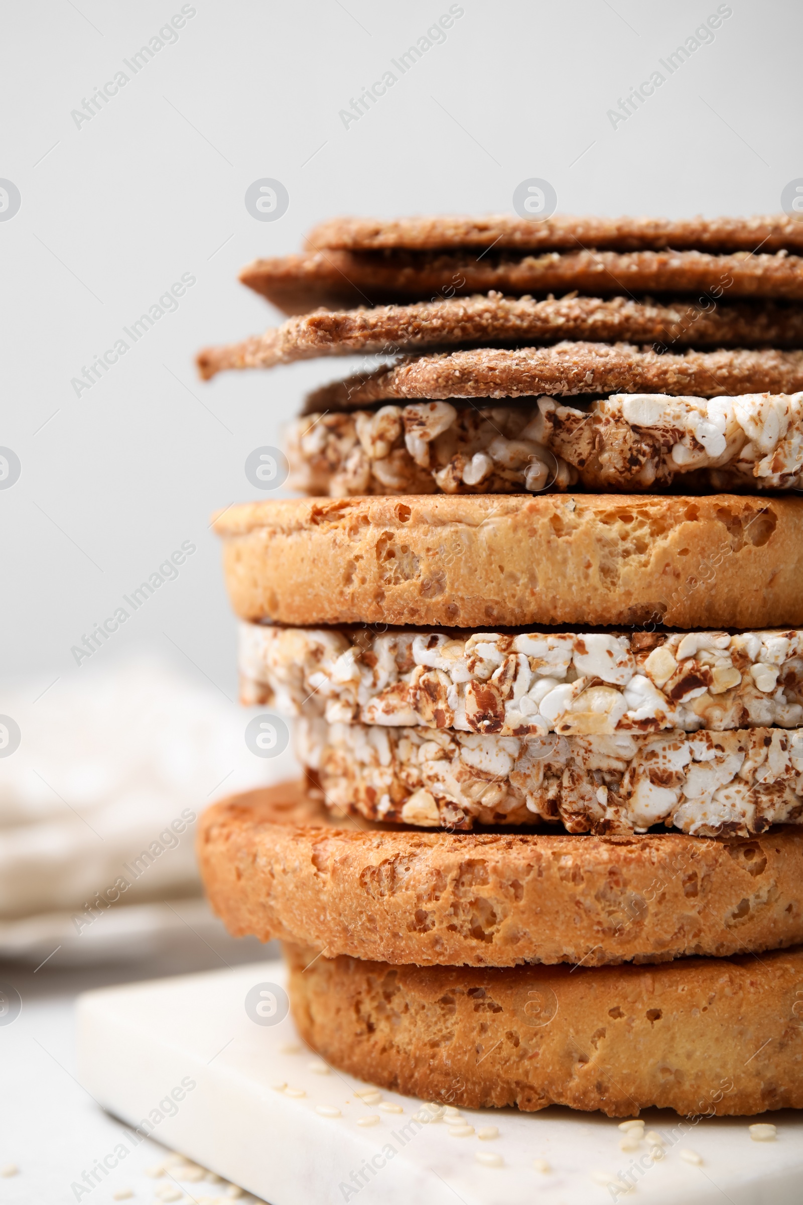 Photo of Stack of rye crispbreads, rice cakes and rusks on table, closeup