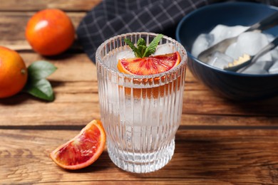 Photo of Delicious refreshing drink with sicilian orange and mint on wooden table