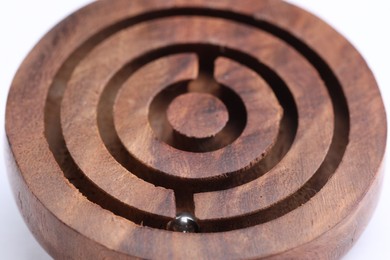 Photo of Wooden toy maze with metal ball on white background, closeup