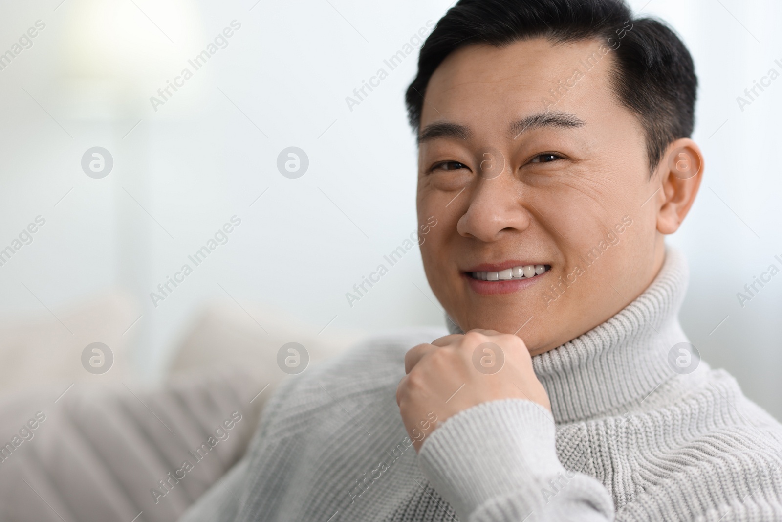 Photo of Portrait of smiling man on blurred background. Space for text