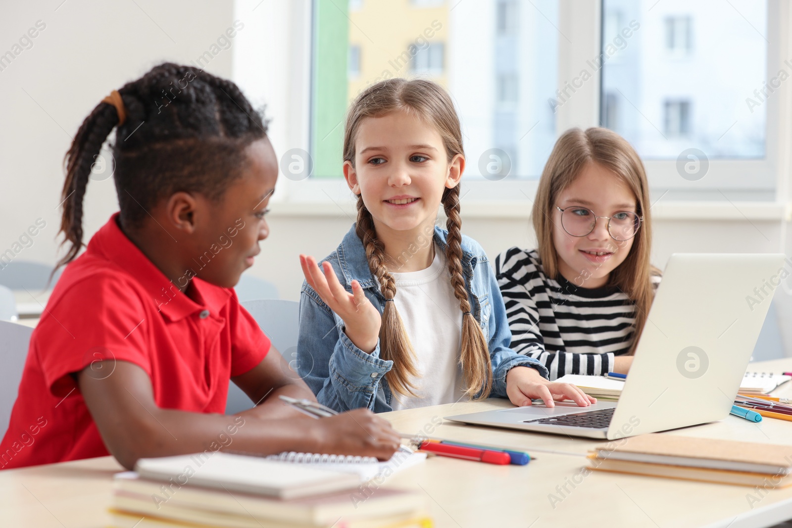 Photo of Cute children studying in classroom at school