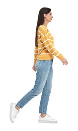 Young woman in jeans and sweater on white background